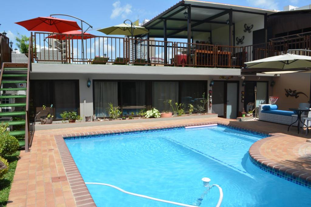 a swimming pool in front of a house at GuestHouse 1109 in Maputo