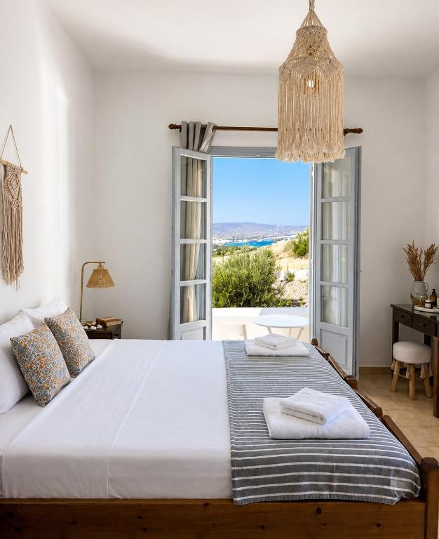 a bedroom with a bed with a view of the ocean at Kirki Rooms on the Hill in Parikia