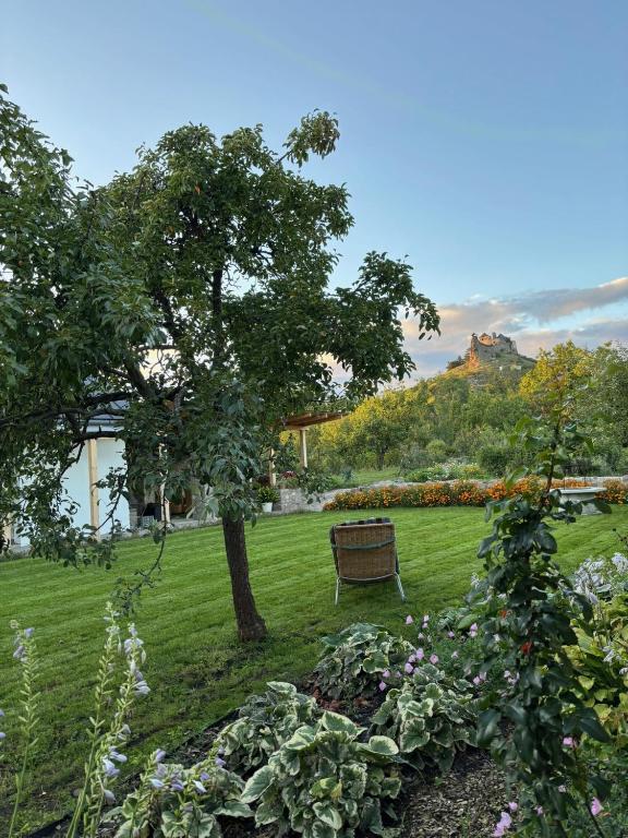 a park with a bench and a tree and flowers at Vitamin K73 Vendégház in Boldogkőváralja