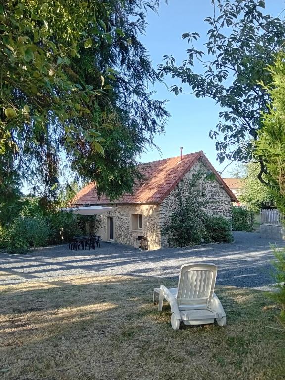 a white chair sitting in front of a building at Gîte cosy 6 personnes, avec jardin en Normandie, proche des plages du débarquement et du Mont Saint-Michel in La Luzerne