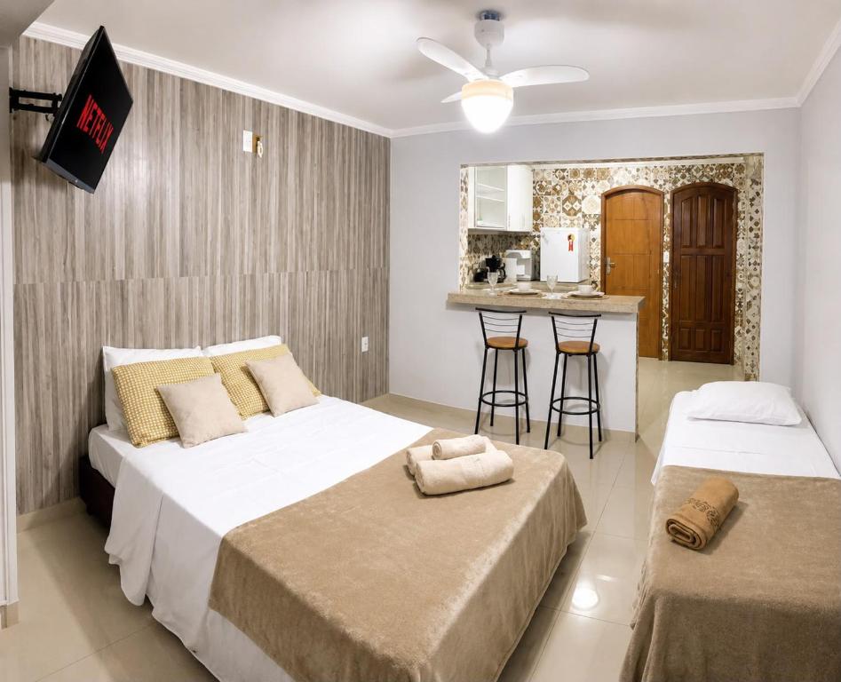 a bedroom with two beds and a kitchen in it at G2 Hospedagem Suites & Studio Praia Dos Anjos in Arraial do Cabo