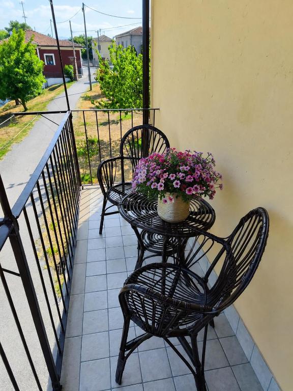a table and chairs with flowers on a balcony at Civico 32 in Mondovì