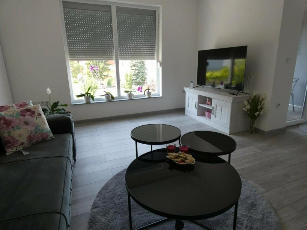 a living room with two tables and a couch at Sokak Apartman in Bihać