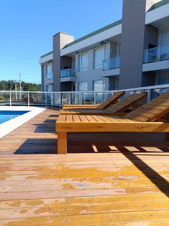 a wooden bench on the deck of a building at Agua de Vida- Parque Termal Chajarí in Chajarí