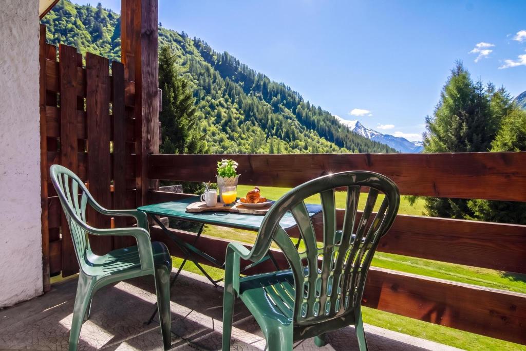 a table and chairs on a patio with a view of mountains at Chalet Dava La Via ski in - ski out - Happy Rentals in Chamonix