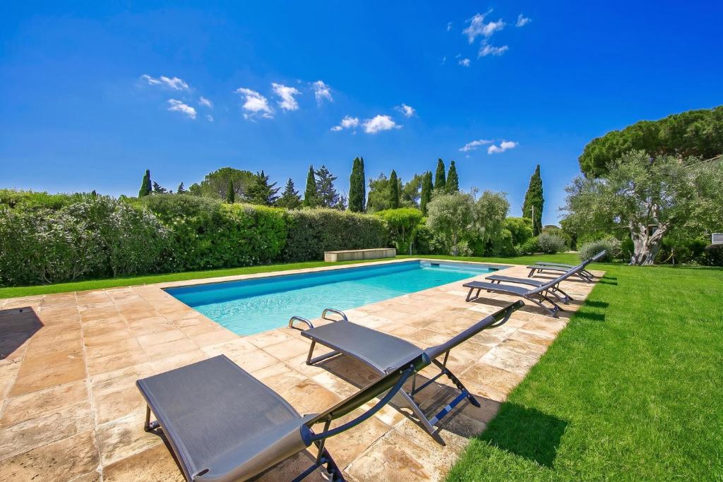 a swimming pool with lounge chairs next to a yard at Chalet Vignarola - Happy Rentals in Orbetello