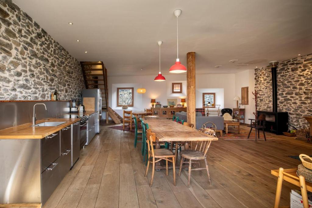 a kitchen with a wooden table and a dining room at Chalet l'Arva in Saint-Marcel