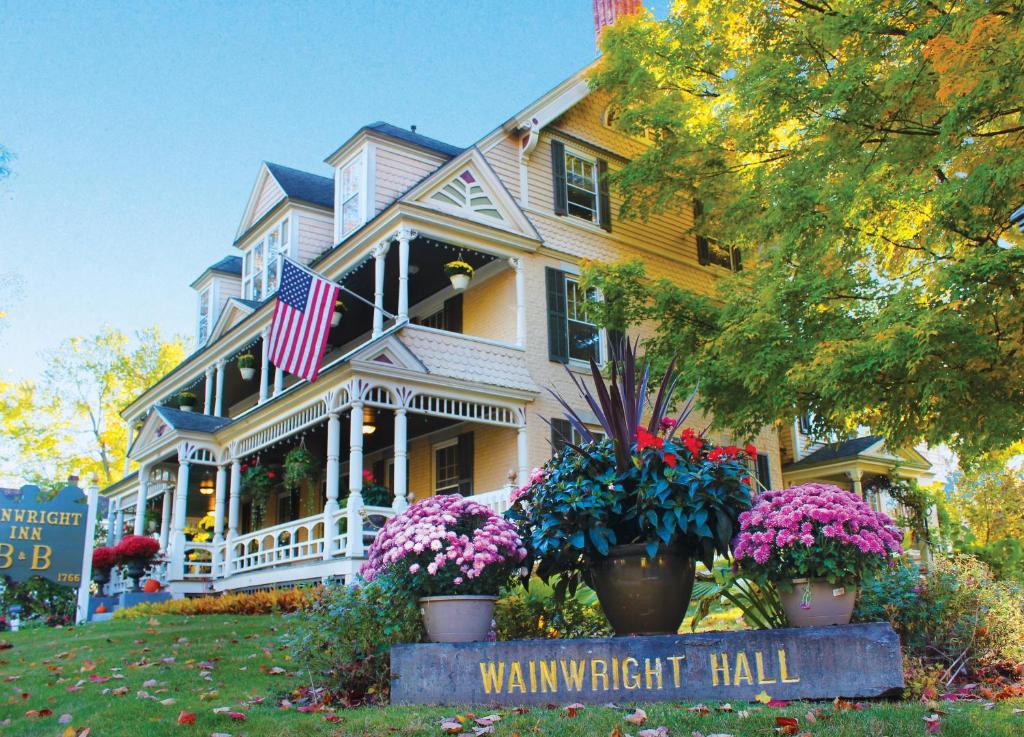 a large white house with flowers in front of it at Wainwright Inn in Great Barrington
