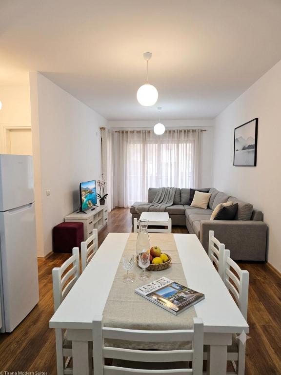 a kitchen and living room with a table and a couch at Spacious Central Apartment with Panoramic Views in Tirane