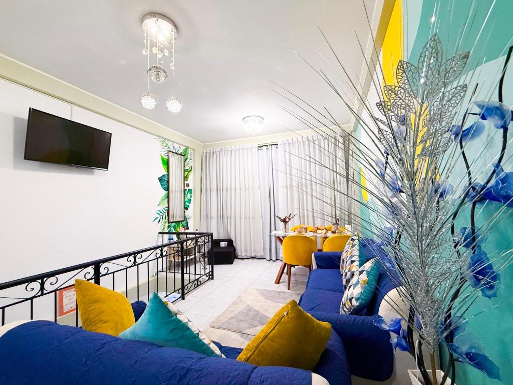 a living room with a blue couch and yellow pillows at Riti Wasi in Yungay