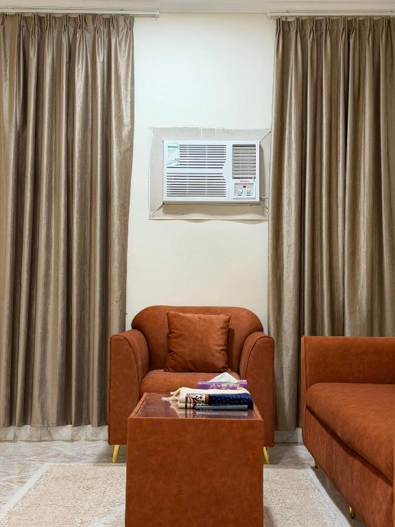 ein Wohnzimmer mit Sofa, Sessel und Tisch in der Unterkunft أجاويد لشقق المفروشة 1 Ajaweed Residence in Salalah