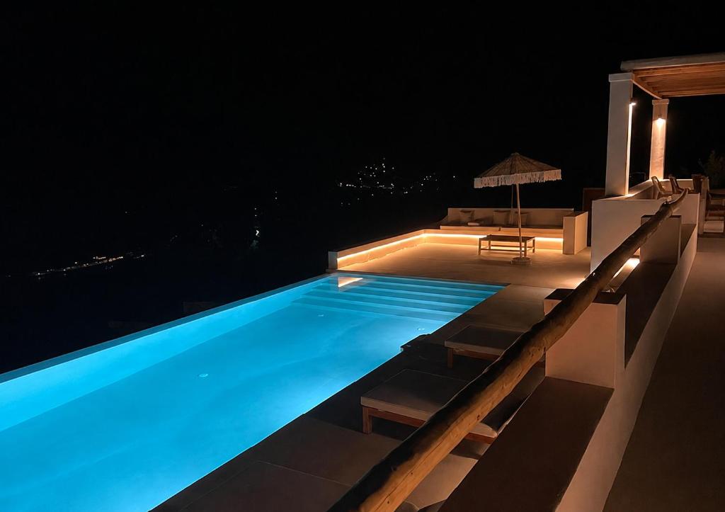 a swimming pool at night with a table and chairs at Cabana Retreat in Agia Effimia