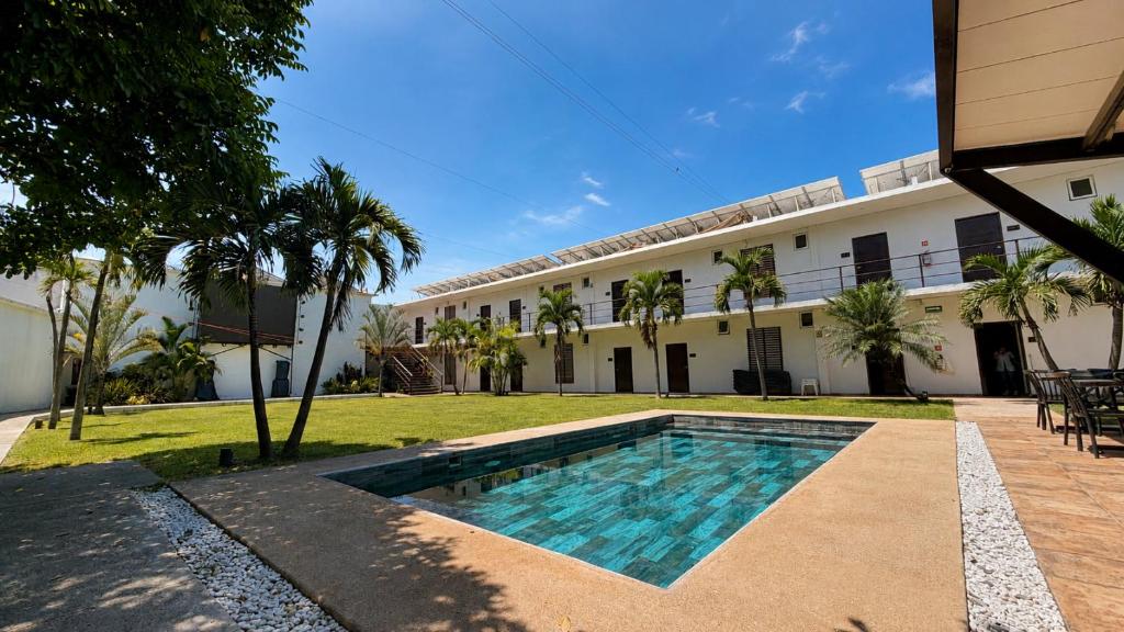 a swimming pool in front of a building at Hotel y Jardín Las Asadas, Bar y Grill in Xochitepec