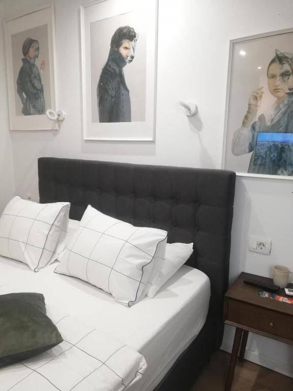 a bedroom with a black and white bed with white pillows at Apartments Simple Teslina in Zagreb