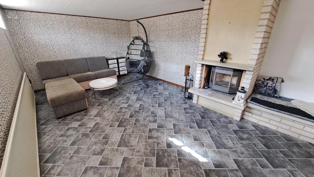 a living room with a couch and a fireplace at Villa Tingsryd nära stranden in Tingsryd
