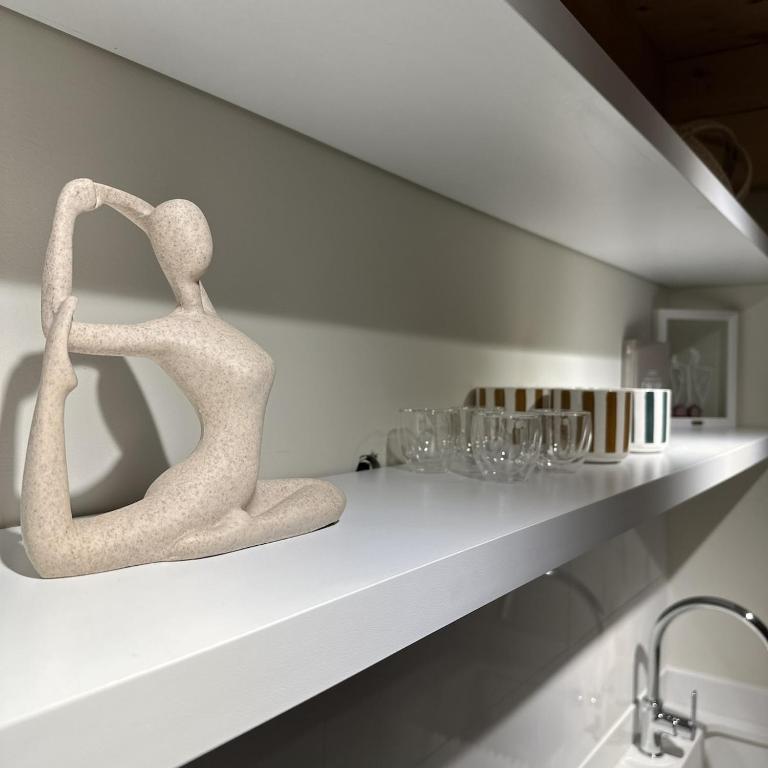 a shelf with two sculptures on it with glasses on it at CBreeze Guesthouse in Batroûn