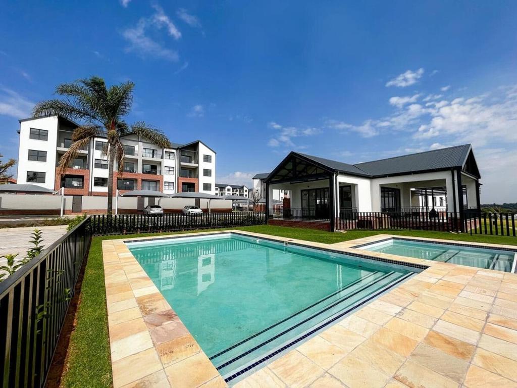 a swimming pool in front of a building at Studio Luxe The Aura Your Calm Escape in Northriding