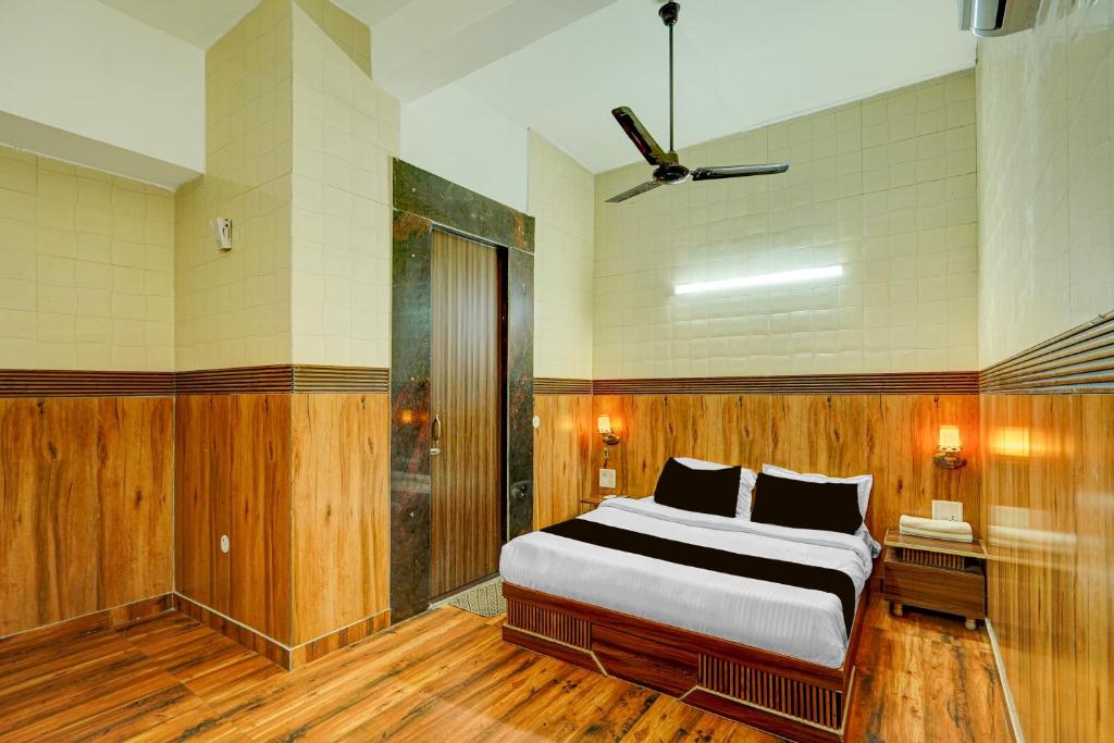 a bedroom with a bed in a room with wooden floors at HOTEL O SAFFRON in Meerut