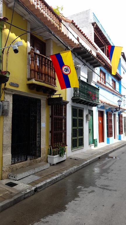 a building with flags on the side of a street at Hostal Casa de las Americas in Cartagena de Indias
