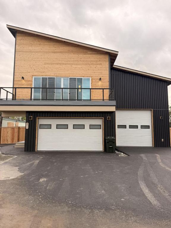 a large house with two garage doors and a balcony at New Modern 2 Bedroom Apartment in Anchorage