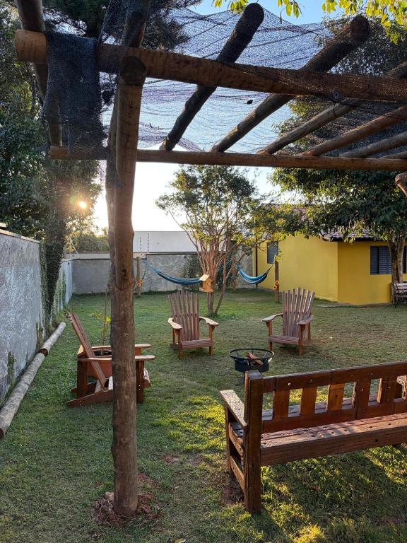 a group of benches sitting in a yard at Casinha Rústica in Indaiatuba