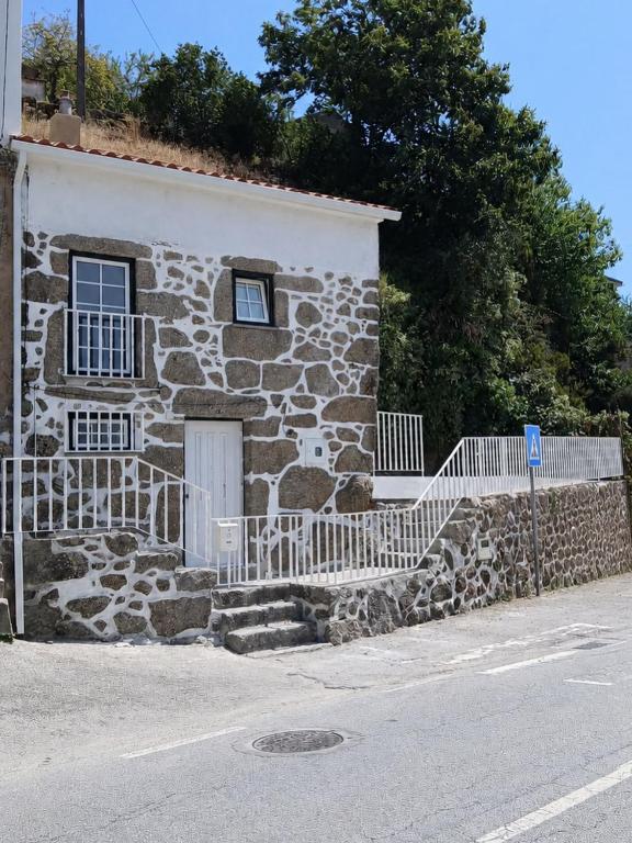 a stone house on the side of a street at Refúgio d’Aldeia da Serra in Seia