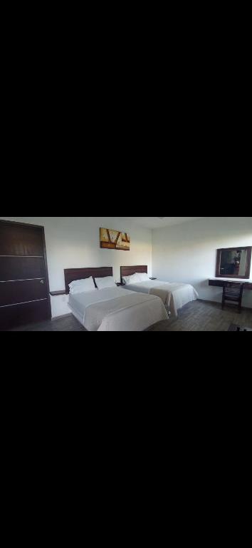 een slaapkamer met twee bedden en een tv aan de muur bij Bambú in Chiconcuac