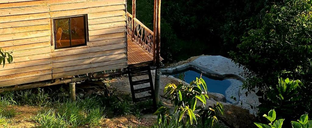 a wooden house with a ladder next to a window at Reserva Wanaka, San Carlos in Cocorná