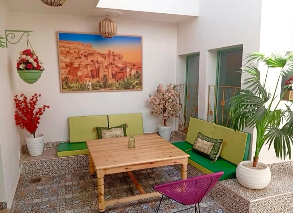 a patio with a wooden table and chairs at Marrakech Premium Dar Aicha in El Gouassem