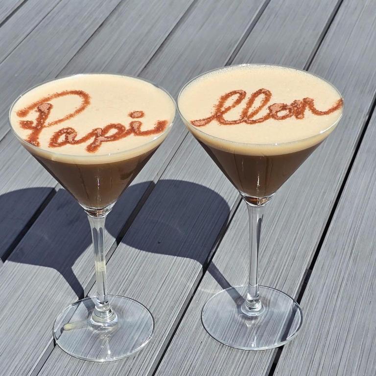two cocktails sitting on top of a wooden table at Papillon 05 - Wellness - 6 Pers - Sauna - Jacuzzi - Yoga - Petanque - Parking in Briançon