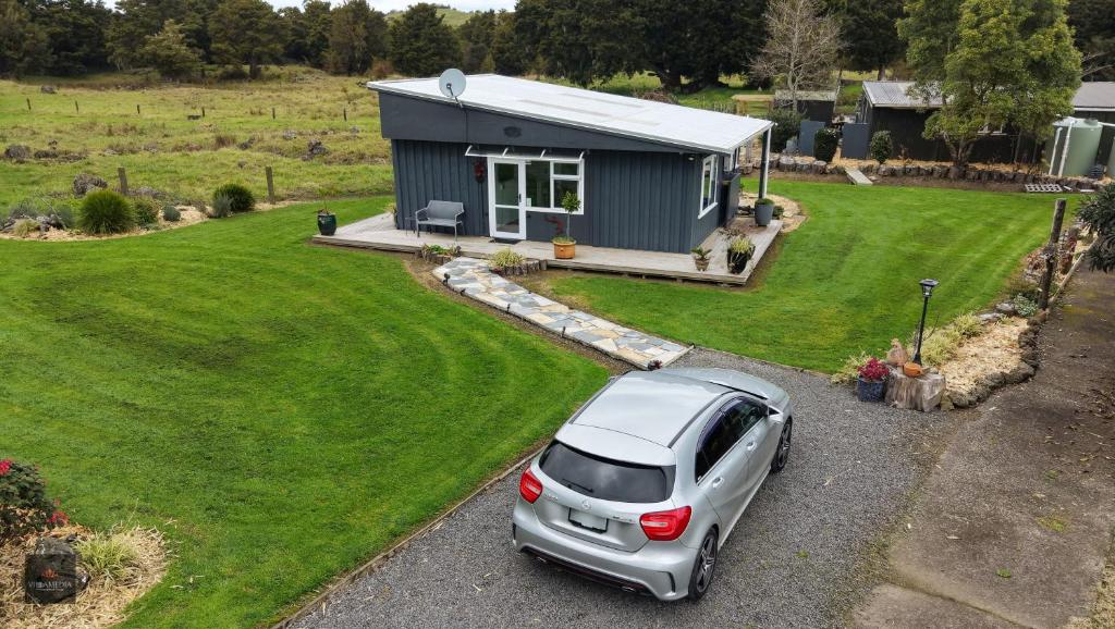 a car parked in front of a tiny house at Oak Lodge in Taheke