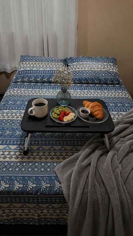 a tray of breakfast foods on a bed at Quarto- WiFi Rápido, Netflix e Cozinha Equipada in Capela do Alto