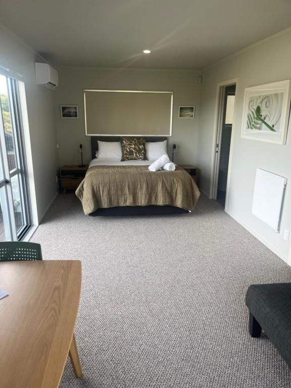 a bedroom with a large bed in a room at STAY WITH US RAGLAN - Studio in Raglan