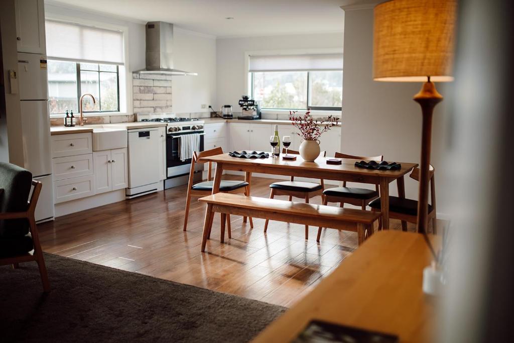 a kitchen with a wooden table and a dining room at Aurum Retreat in Reefton