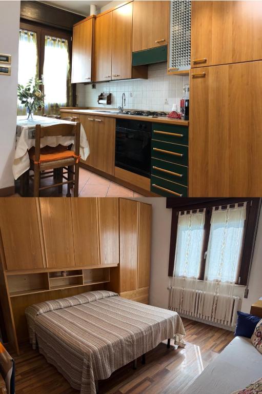 a kitchen with wooden cabinets and a bed in a room at Alloggi Al Giardino & La Suite in Occhiobello