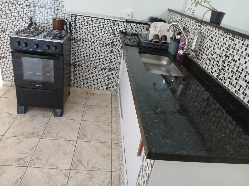 a kitchen with a sink and a stove at Casa Progresso in Juiz de Fora