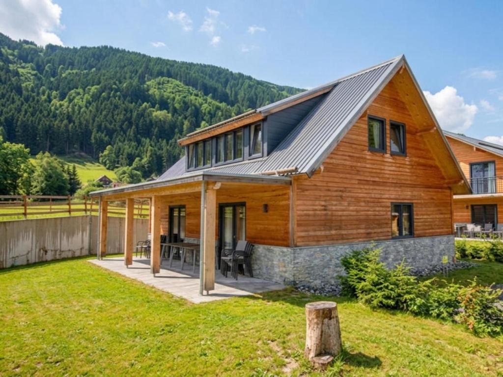 a home with a gambrel roof with a patio at Bergblick am Afritzer See in Afritz