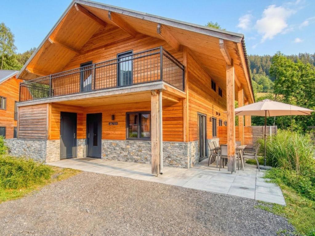 a log home with a deck and an umbrella at Verditzblick in Afritz