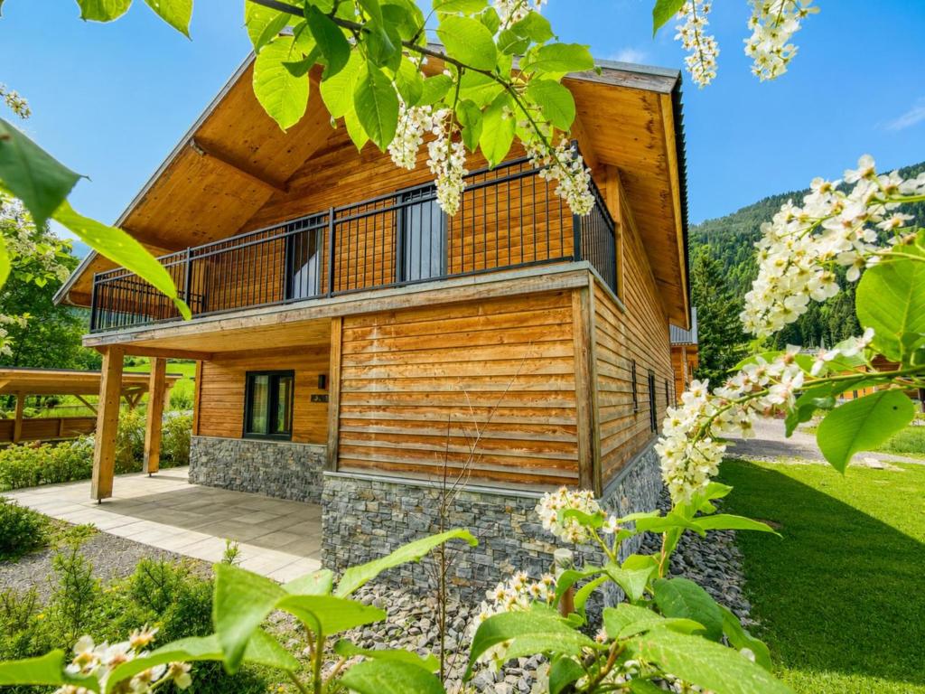 a house in the woods with a wooden facade at Alpensehnsucht in Afritz