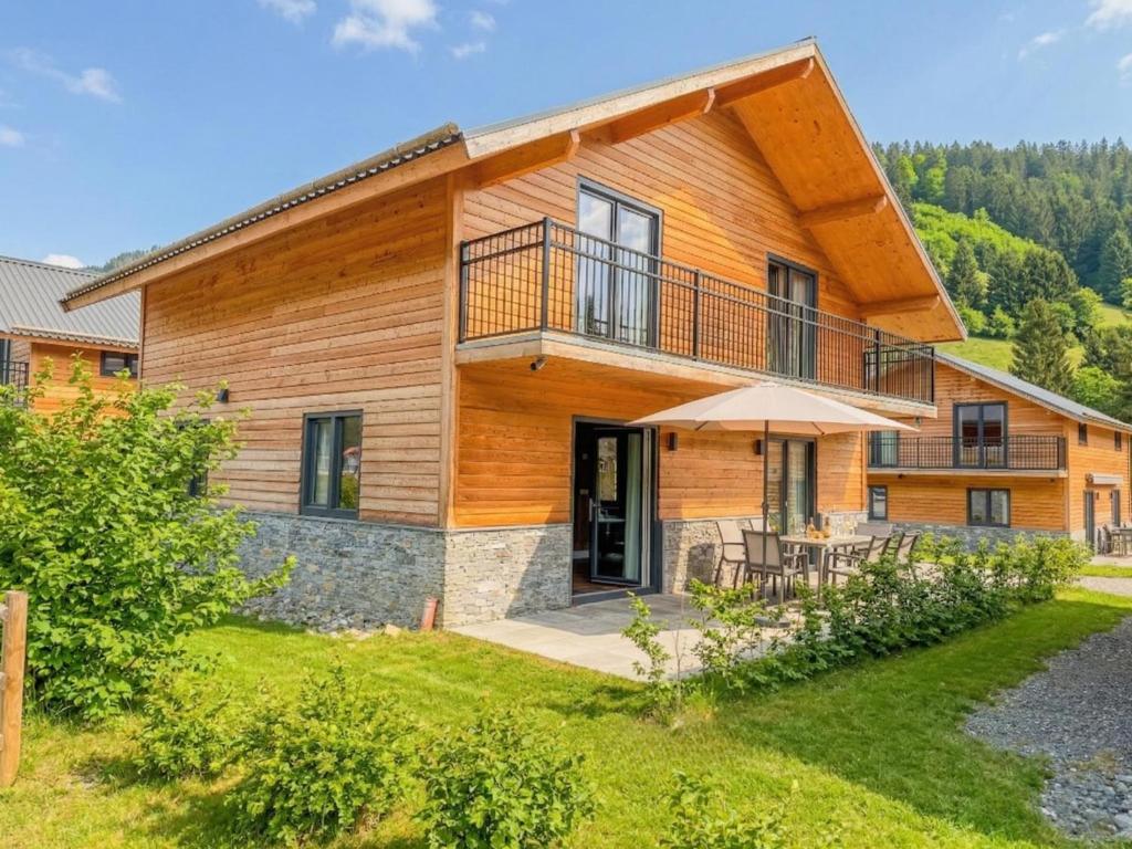 a log home with a deck and a patio at Alpenchalet Afritz am See in Afritz