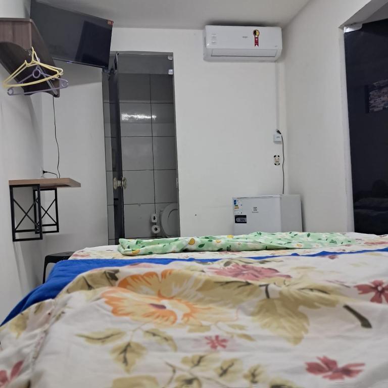 a hospital room with a bed with a floral blanket at Central in Juazeiro do Norte