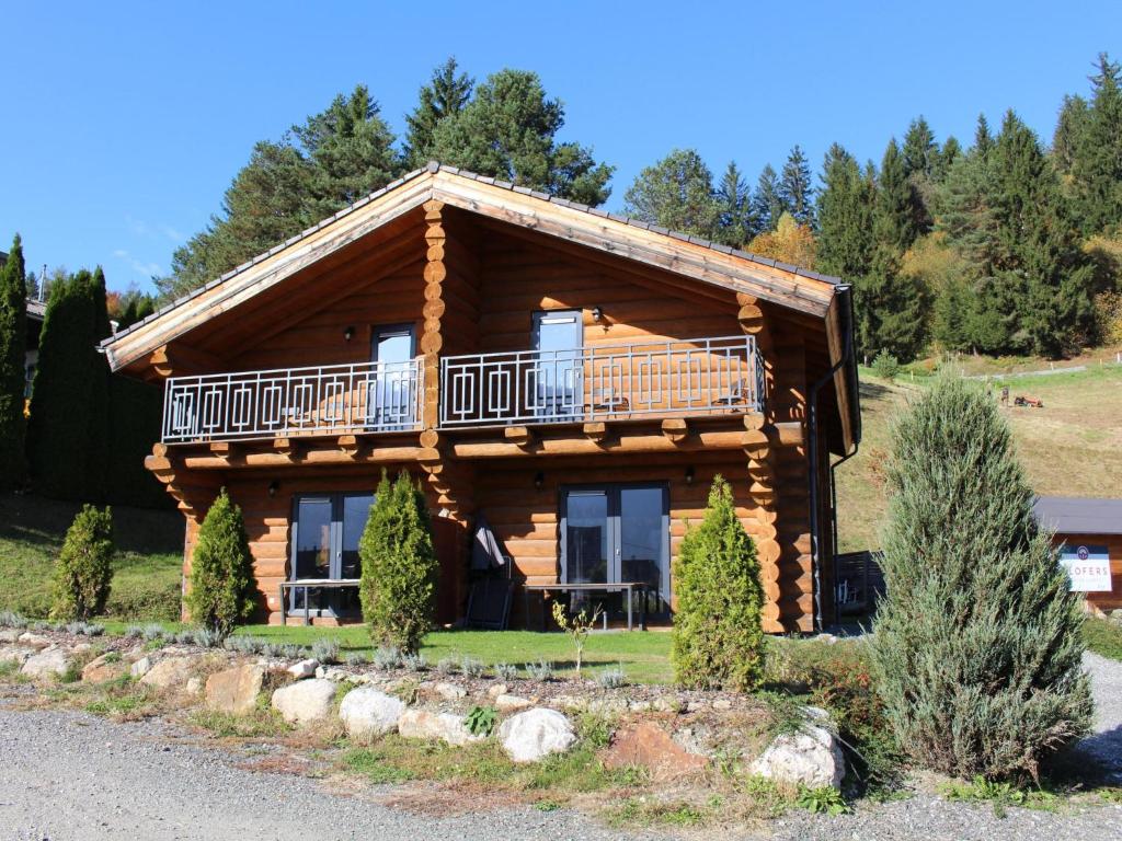 a log cabin with a balcony on the side of it at Jenig 1A in Jenig