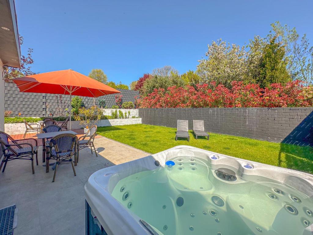 a hot tub in a backyard with a table and chairs at Zicht op Valkenburg in Schin op Geul