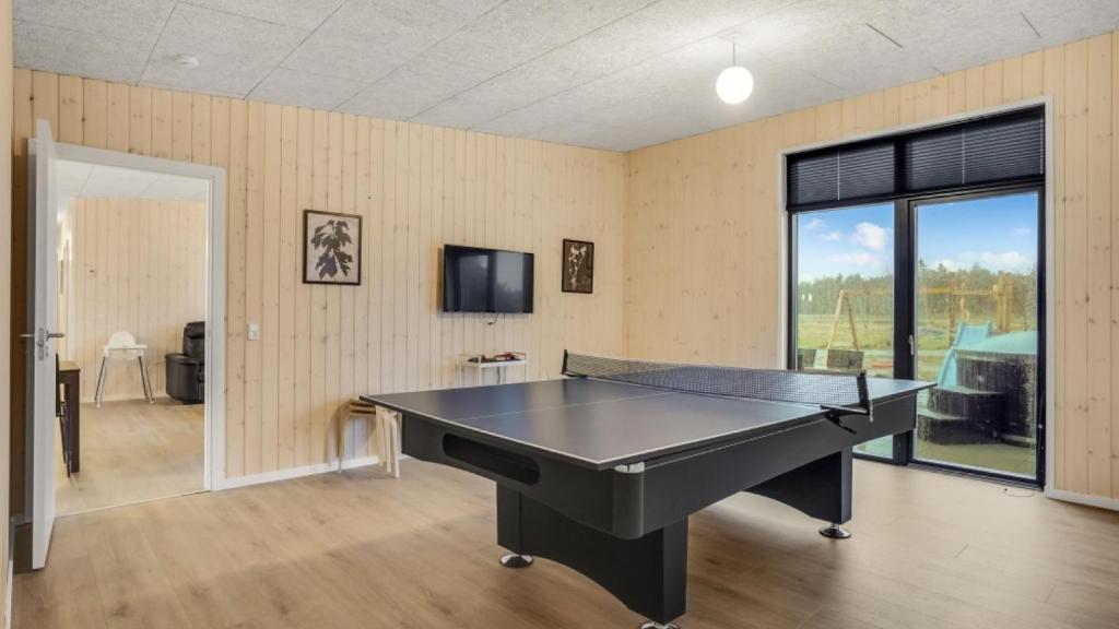 a ping pong table in a room with a tv at Villavilla 581 - Gjerrild, Østjylland in Grenå