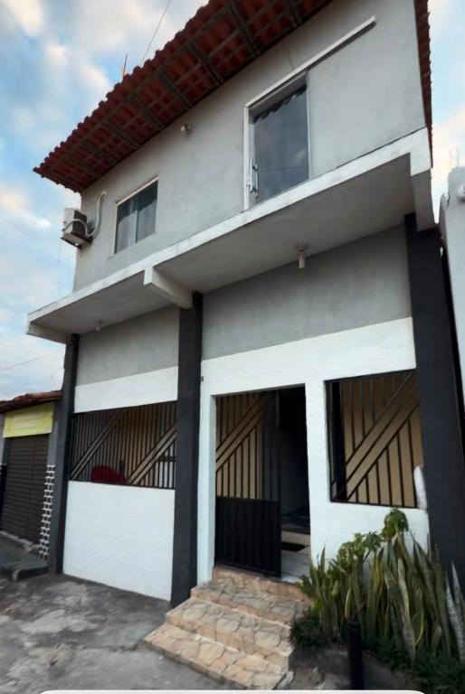 a white house with two garage doors at Casa Dunas Temporada in Barreirinhas