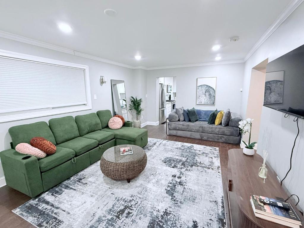 a living room with a green couch and a table at Glam Parkville Experience! in Parkville