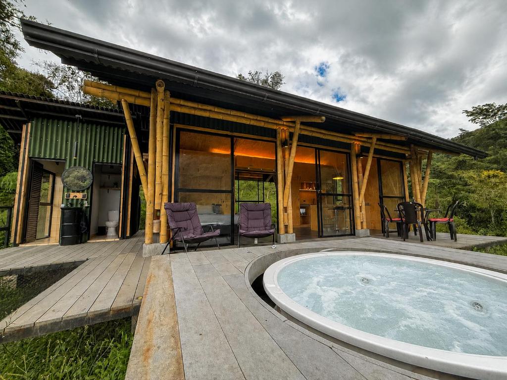 a house with a hot tub on a patio at Glamping Bosque de helechos, privacidad y cercanía in Manizales