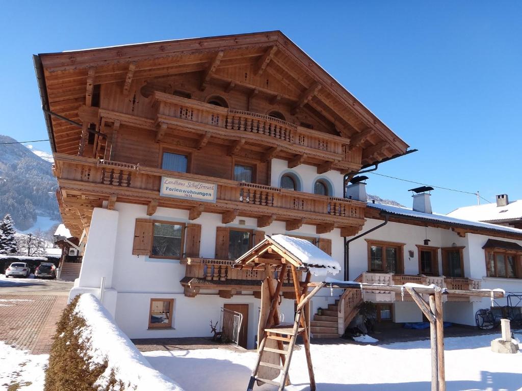 a building in the snow with a ladder in front at Ferienwohnung Schaffenrath in Kaltenbach