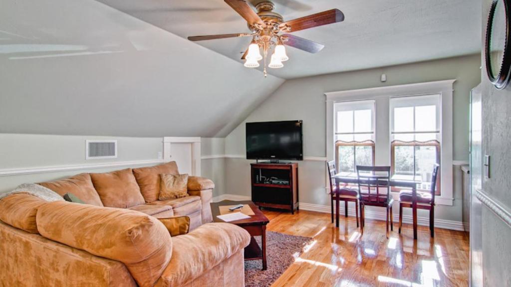 a living room with a couch and a ceiling fan at Hustons Attic by AvantStay in Paso Robles
