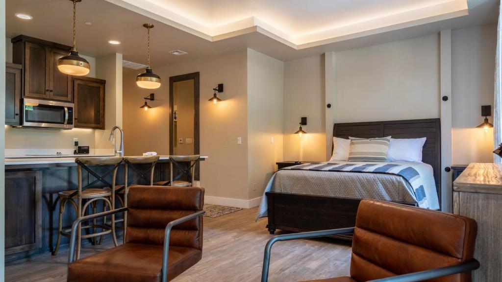 a bedroom with a bed and a kitchen with a counter at Paso Park Suites by AvantStay in Paso Robles